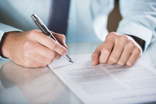 Un avocat entrain de signer un contrat commercial et il aide pour vérifier