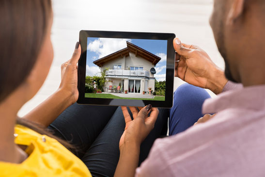 Personnes qui regardent une maison et qui cherchent un avocat en droit immobilier